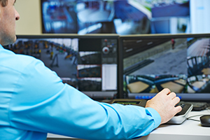 Man monitoring surveillance monitor screens